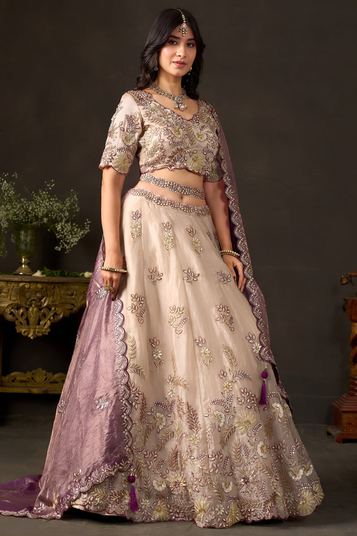 Light beige wedding guest lehenga flat lay, skirt panels with zari floral motifs.