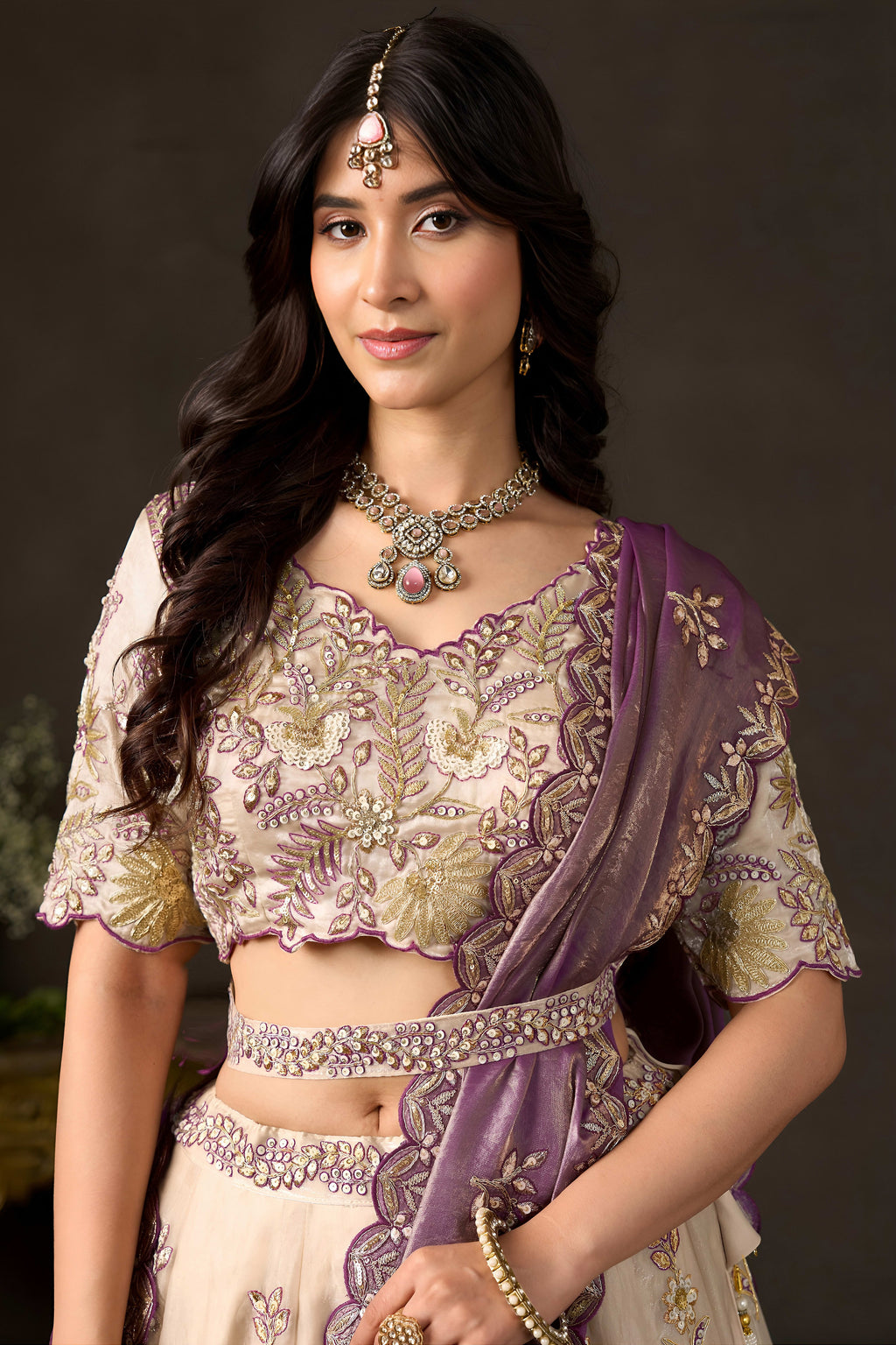 Light beige reception lehenga choli on model, side view showing flared fendy silk skirt.