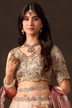 Light beige engagement lehenga on mannequin, front view with draped fendy silk dupatta.