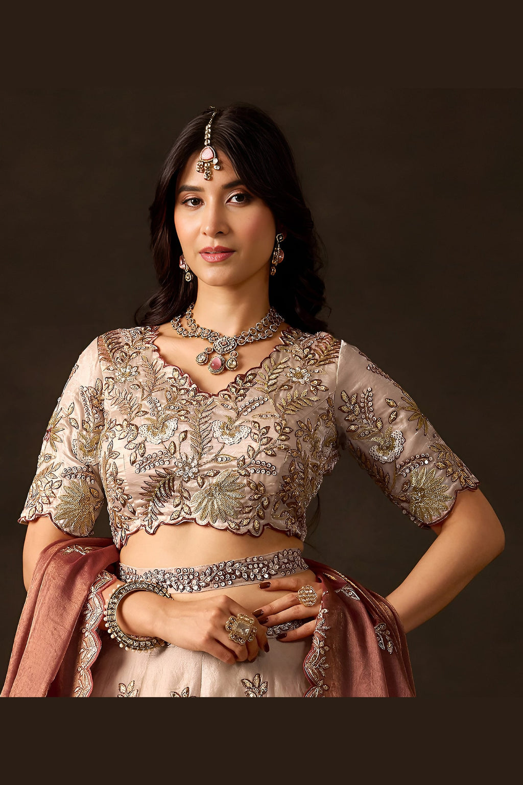 Light beige engagement lehenga choli on model, side view showing flared embroidered skirt.
