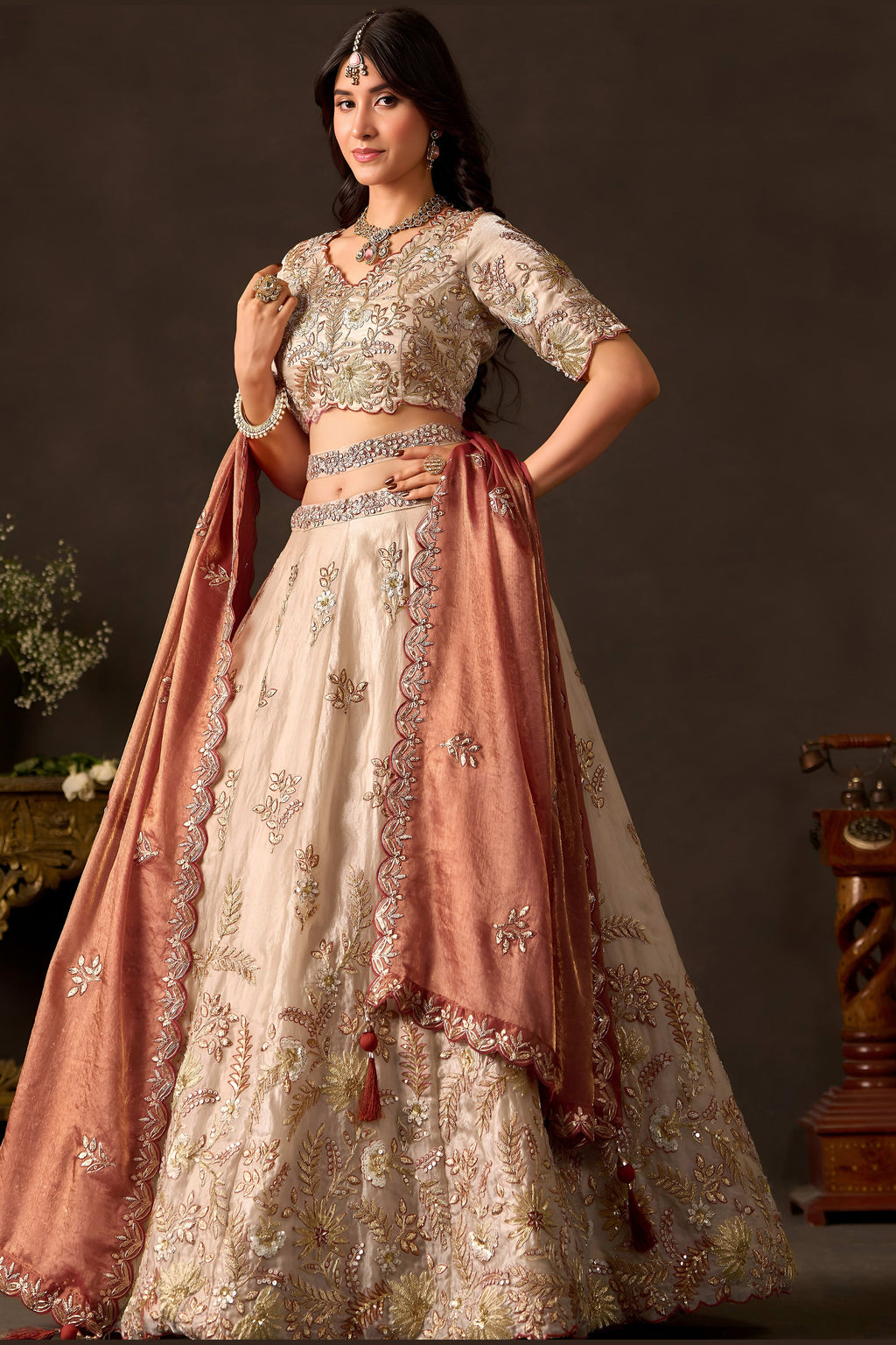 Light beige indian lehenga choli with dupatta, full length view on model.