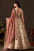 Light beige silk lehenga choli, three-quarter front view, V neck blouse with half sleeves.
