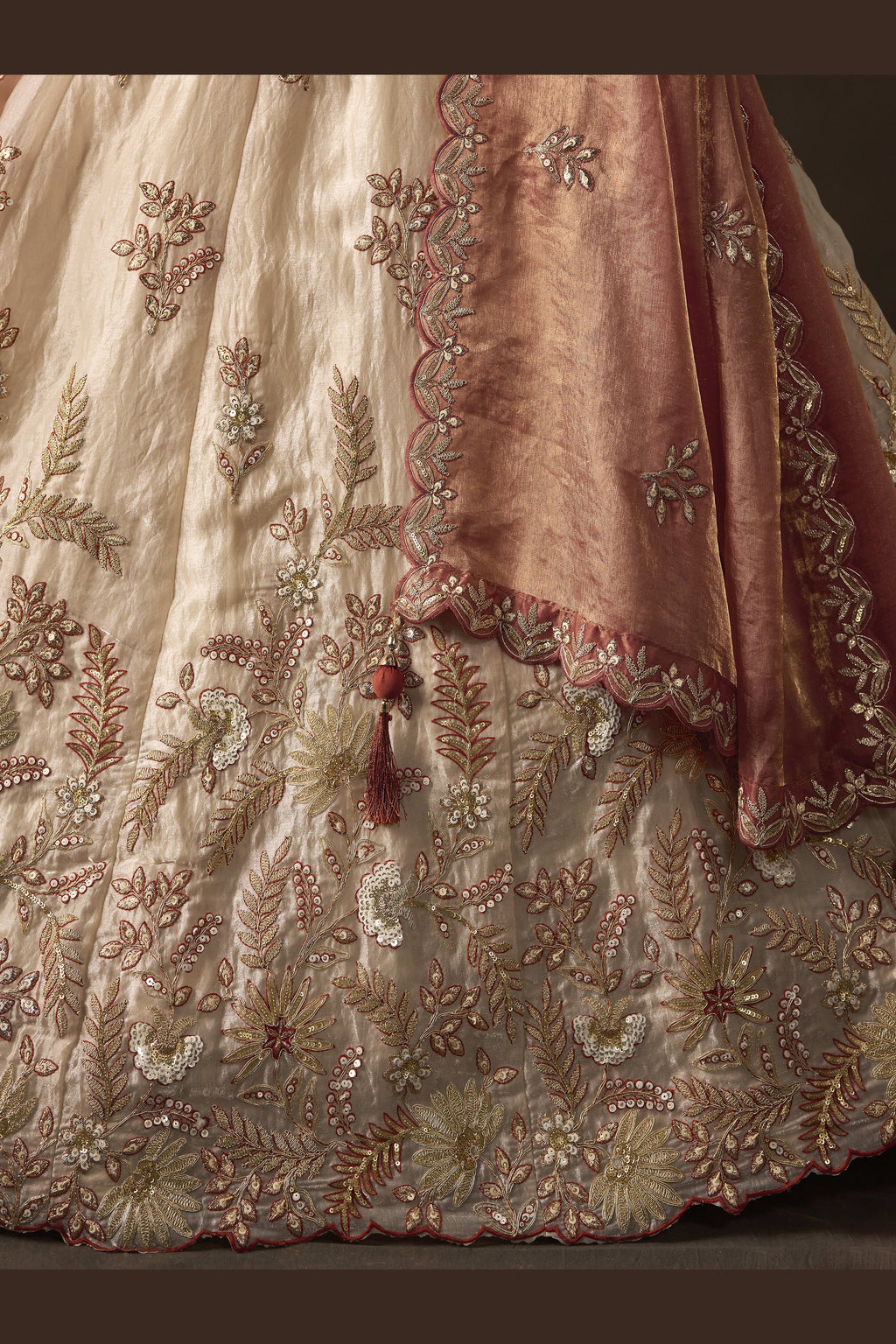 Close-up of light beige indian lehenga blouse, zari and sequin embroidery detail.