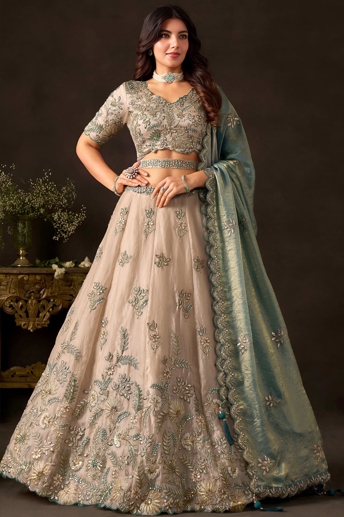 Detail of light beige lehenga skirt hem, zari thread and sequin embroidery on fendy silk.