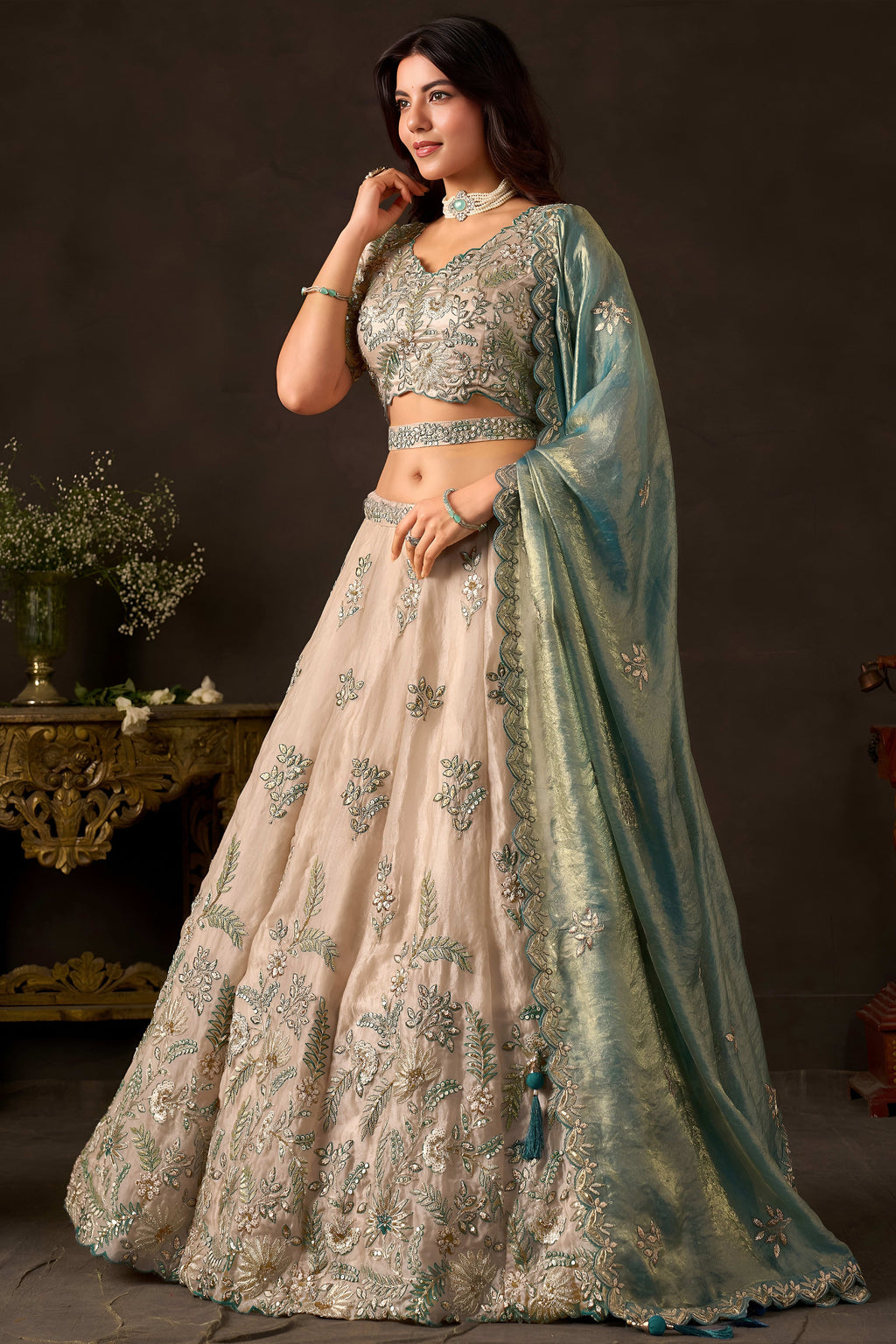 Light beige engagement lehenga flat lay, blouse and skirt with zari border work.