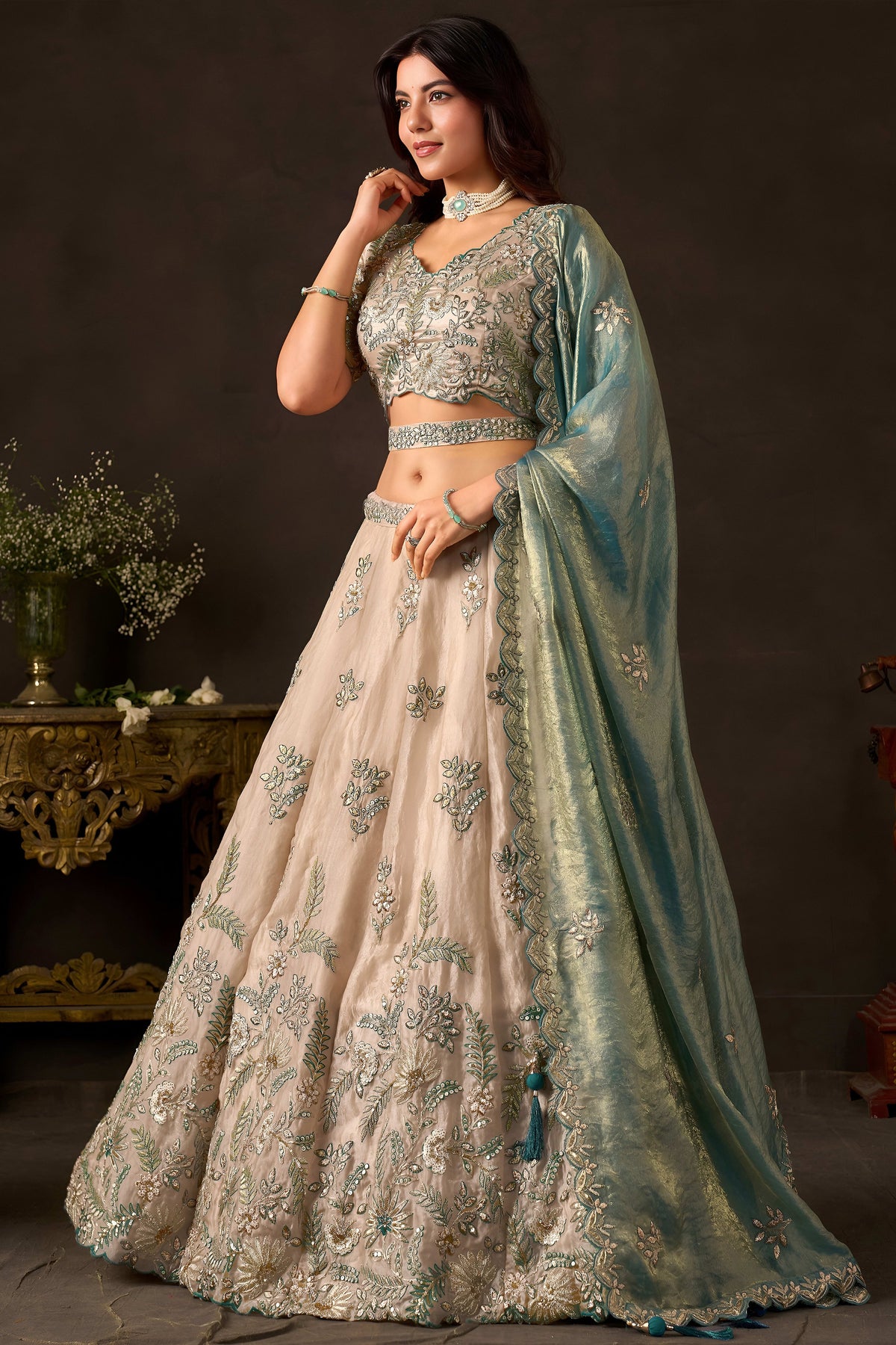 Light beige engagement lehenga flat lay, blouse and skirt with zari border work.