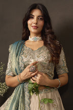 Light beige indian lehenga choli on mannequin, front view with draped fendy silk dupatta.
