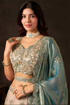 Light beige indian lehenga choli on model, side view displaying flared skirt with thread and sequin embroidery.