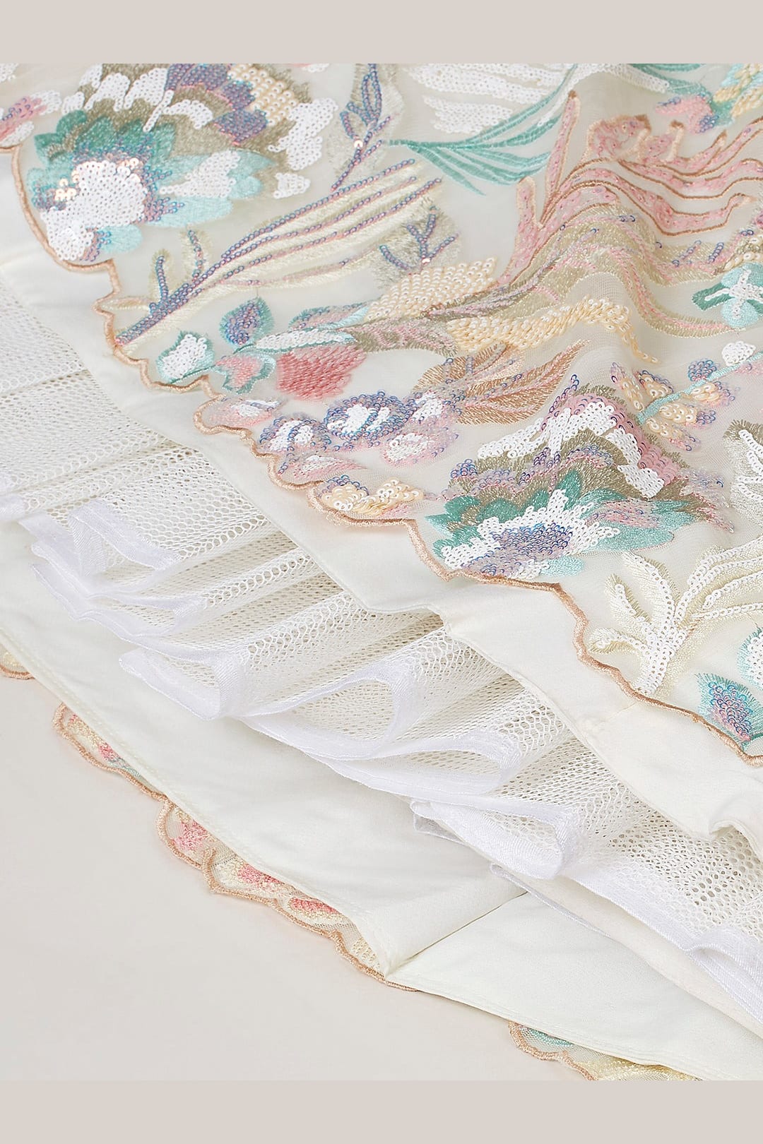 Beige Cream lehenga for diwali, close-up of the lehenga border and hem work, featuring thread and sequins embroidery work on net fabric.