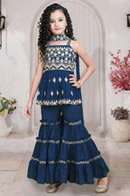 Young girl in a traditional outfit with floral patterns in a decorated room.