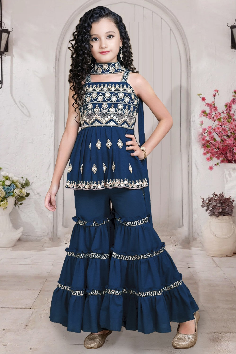 Young girl in a traditional outfit with floral patterns in a decorated room.