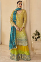 Woman wearing a yellow outfit for turmeric wedding ceremony embroidered traditional outfit with a blue dupatta