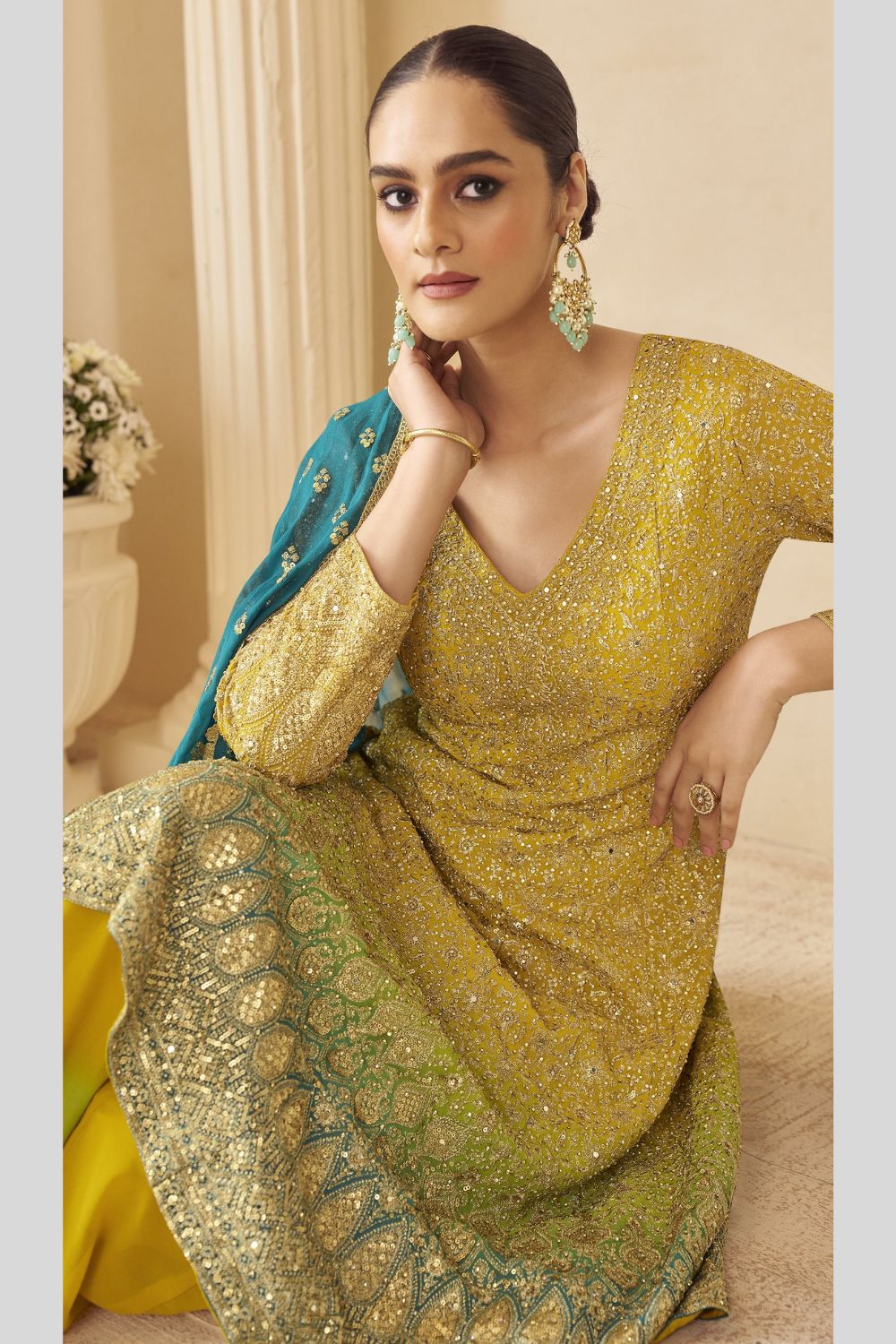 Woman in a yellow turmeric wedding ceremony outfit with floral background